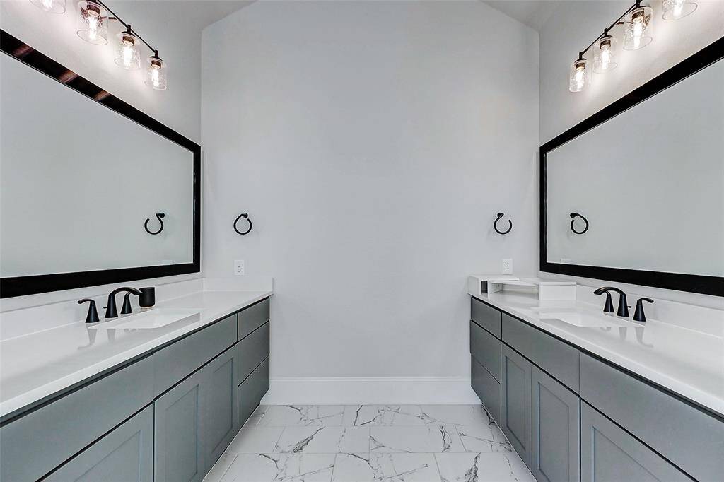 Welcome to your spa-like ensuite bathroom, where luxury and thoughtful design come together. Dual vanities are positioned opposite one another, each offering generous counter and cabinet space, under-mount sinks, framed mirrors, and upgraded lighting. Elegant bronze finishes add a sophisticated touch.