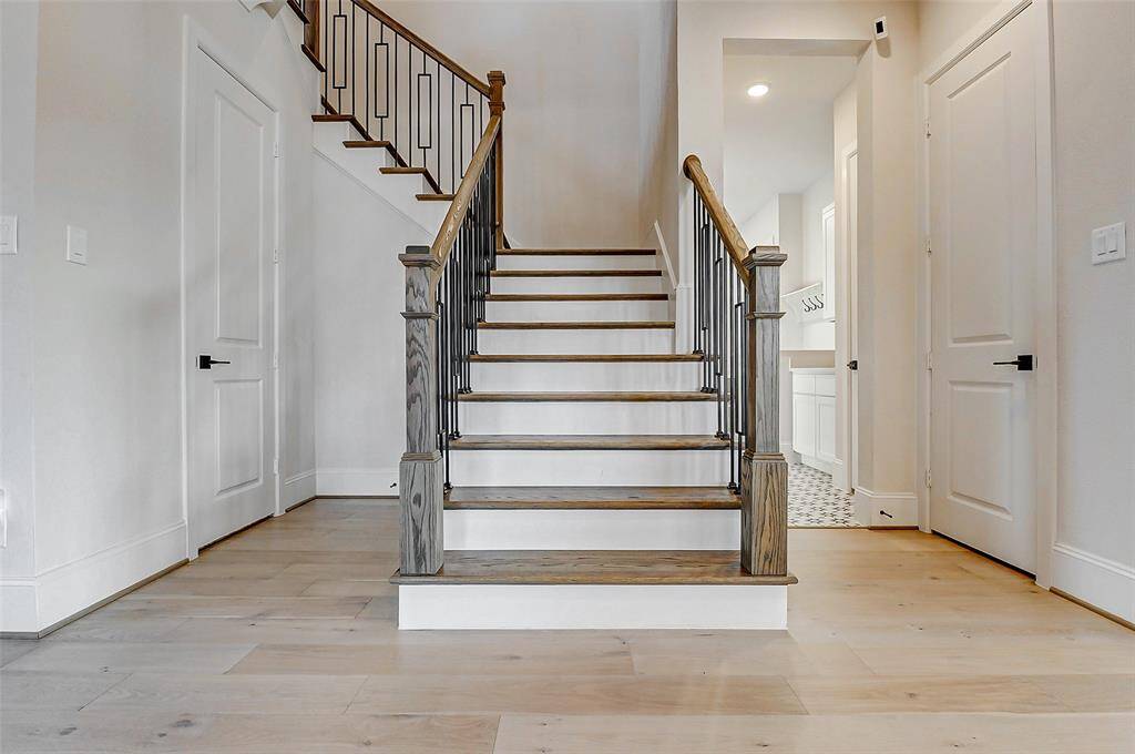 Ascend the wooden staircase, beautifully appointed with elegant wood railings and wrought iron balusters, to the second level of the home—where you’ll discover a spacious game room, media room, and well-appointed secondary bedrooms. The generously sized downstairs storage closet provides convenient space for keeping belongings neatly organized.