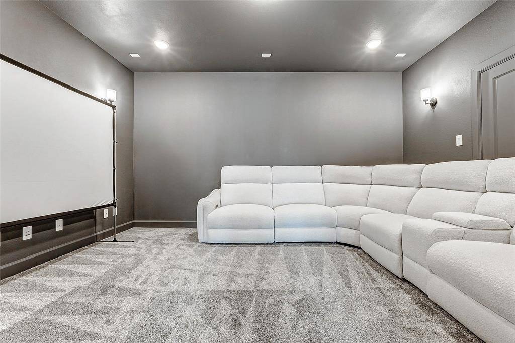 Welcome to your incredible media room, featuring plush carpet, color-rich walls, recessed lighting, and pre-wiring for a 7.1 sound system—creating the ultimate space for cinematic experiences.