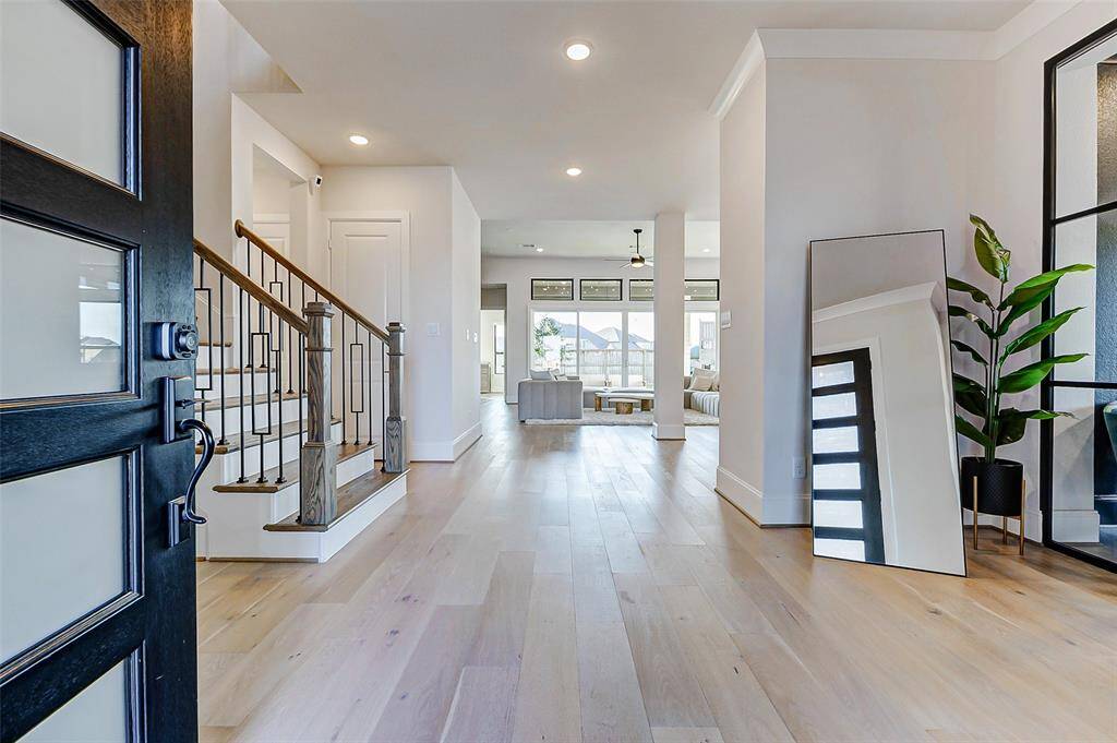 Welcome in! This stunning entryway sets the tone for the entire home with its soaring ceilings, designer paint palette, and upgraded wide-plank wood flooring—creating an immediate sense of sophistication and style.