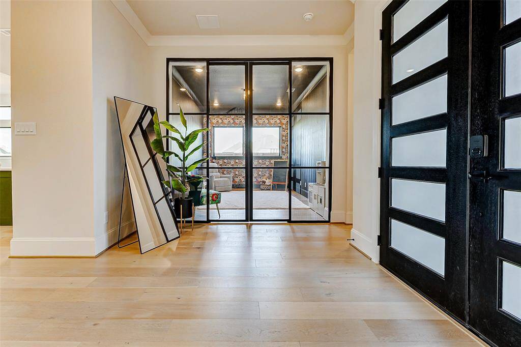 Enclosed by sleek black metal-framed double doors with custom sliding glass, this stunning study offers a refined and private workspace, perfect for productivity in style.