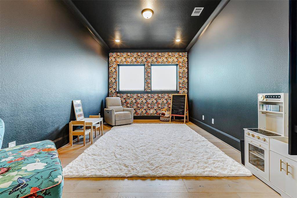 Step into the office and be captivated by a color drenched space, highlighted by a striking accent wall that immediately draws the eye. Other features include hardwood floors, recessed lighting, and two large windows that fill the room with natural light, creating an inspiring and inviting atmosphere.