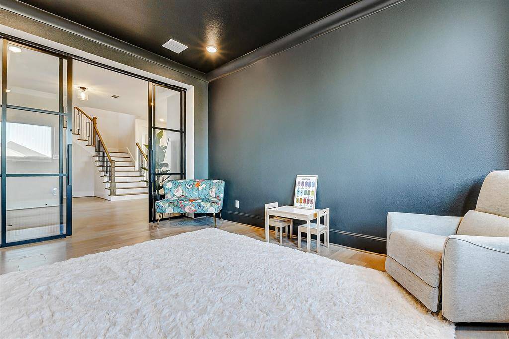 An alternate view reveals the custom doors open, seamlessly connecting this versatile space to the rest of the home. Ideal as a home office, playroom, workout area, or flexible living space tailored to your needs.