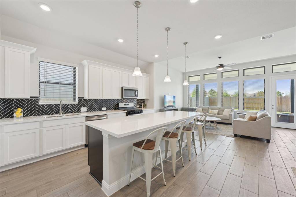 Modern kitchen with breakfast bar, all modern appliances and double sink with quartz countertops.