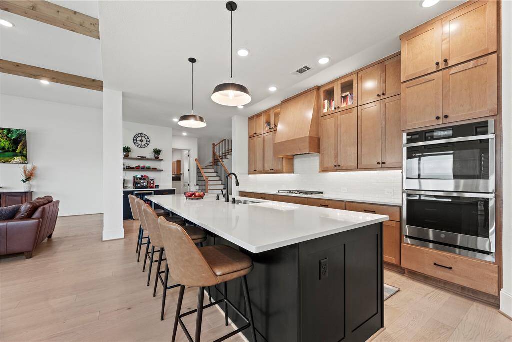 Your chef-inspired kitchen is ready to impress! This beautifully designed space boasts gleaming quartz countertops, a coordinating backsplash, and sleek stainless steel appliances. The rich cabinetry, enhanced with updated hardware, is perfectly complemented by under-cabinet lighting, recessed lighting, creating a bright and inviting ambiance. At the heart of it all, a sprawling pendant lit island with breakfast bar seating offers the perfect spot for casual dining and entertaining.