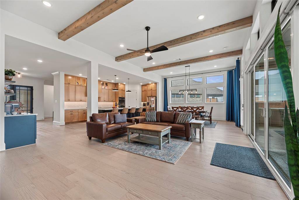 High ceilings can draw the eye upward, adding a sense of grandeur and elegance to the room. The exposed beams create a dramatic focal point that complements the overall aesthetic of this gorgeous open living space.