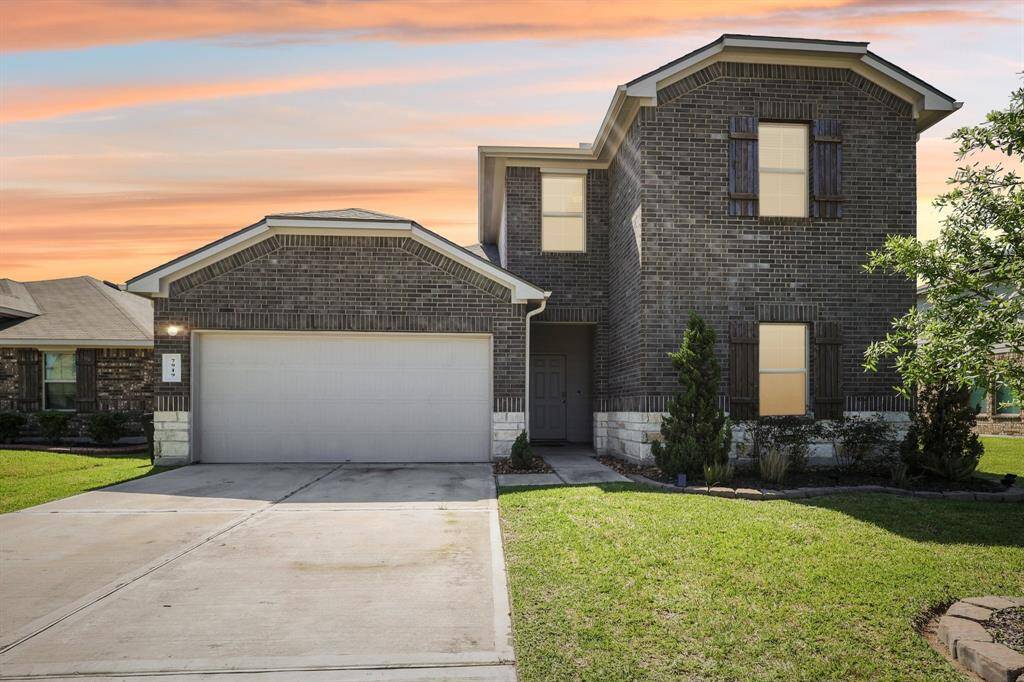 Stunning front view at dusk, showcasing a spacious driveway and charming brick façade. Perfect blend of elegance and comfort.