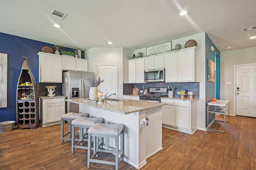 Discover a spacious, modern kitchen featuring sleek cabinetry, stainless steel appliances, and a stylish island perfect for entertaining.