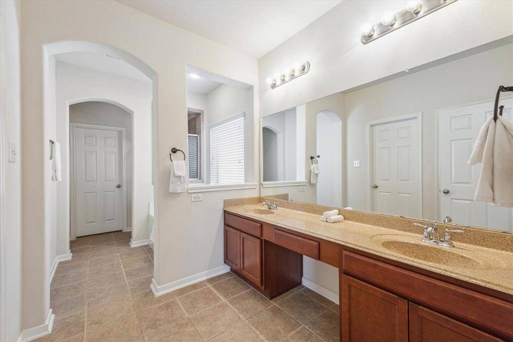 Primary ensuite bathroom w/ dual sinks & separate soaking tub & shower
