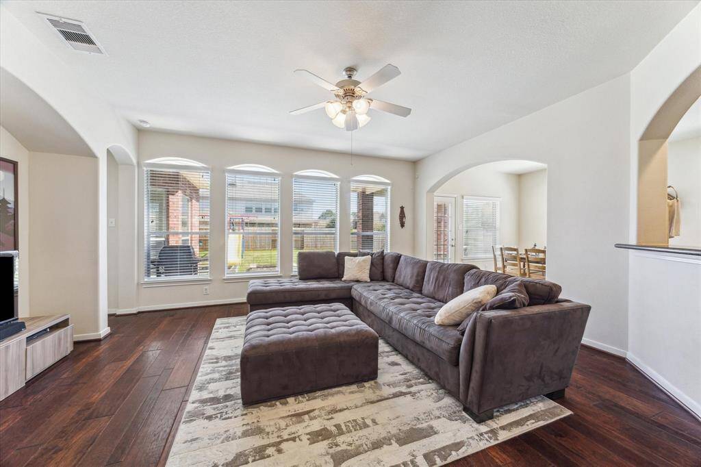 Spacious family room w/ wood floors and large windows that bring in an abundance of light.