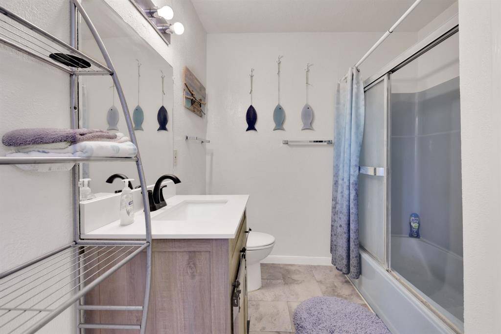 The bathroom features a vanity and a combination tub and shower.