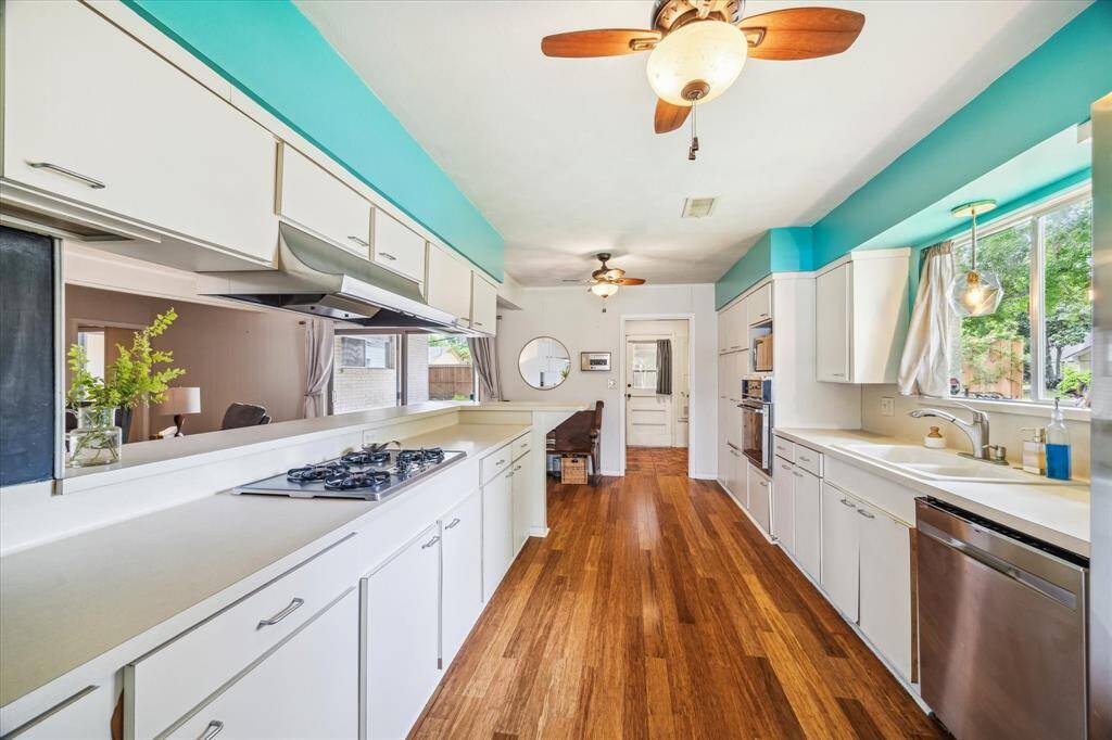 Opposite view of the kitchen with ample window space for great natural light and gas cooktop.  Utility room at far end just beyond the breakfast area.