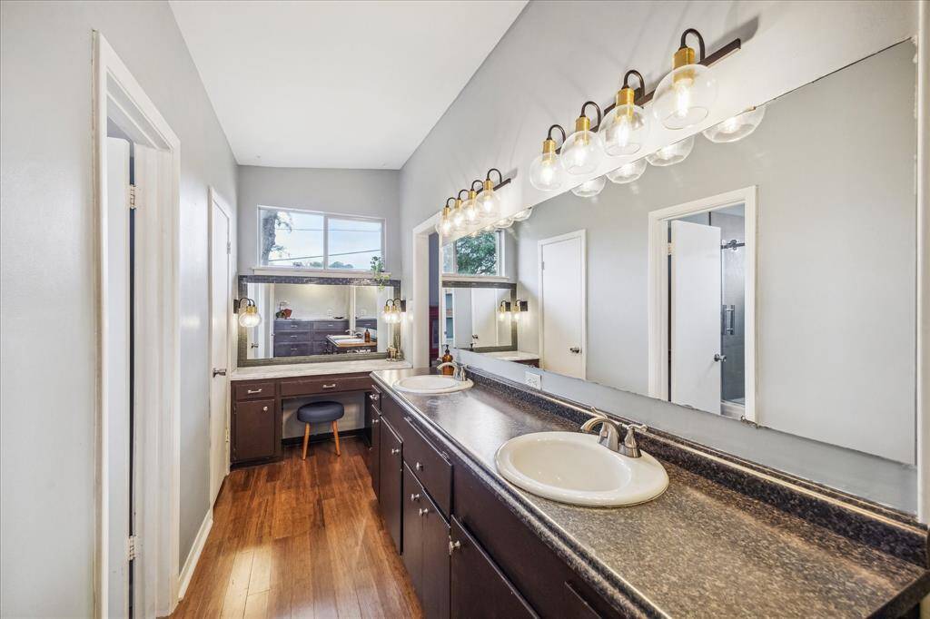 The adjacent en suite bath and dressing area features DUAL his & hers walk in closets, double sinks, an extra vanity table, natural light, and a separate space for the shower.