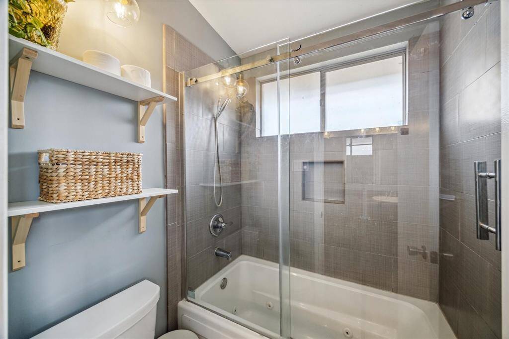 Tub enclosure has been updated but in keeping with the modernist style of the home.  Additional natural light in this space also.