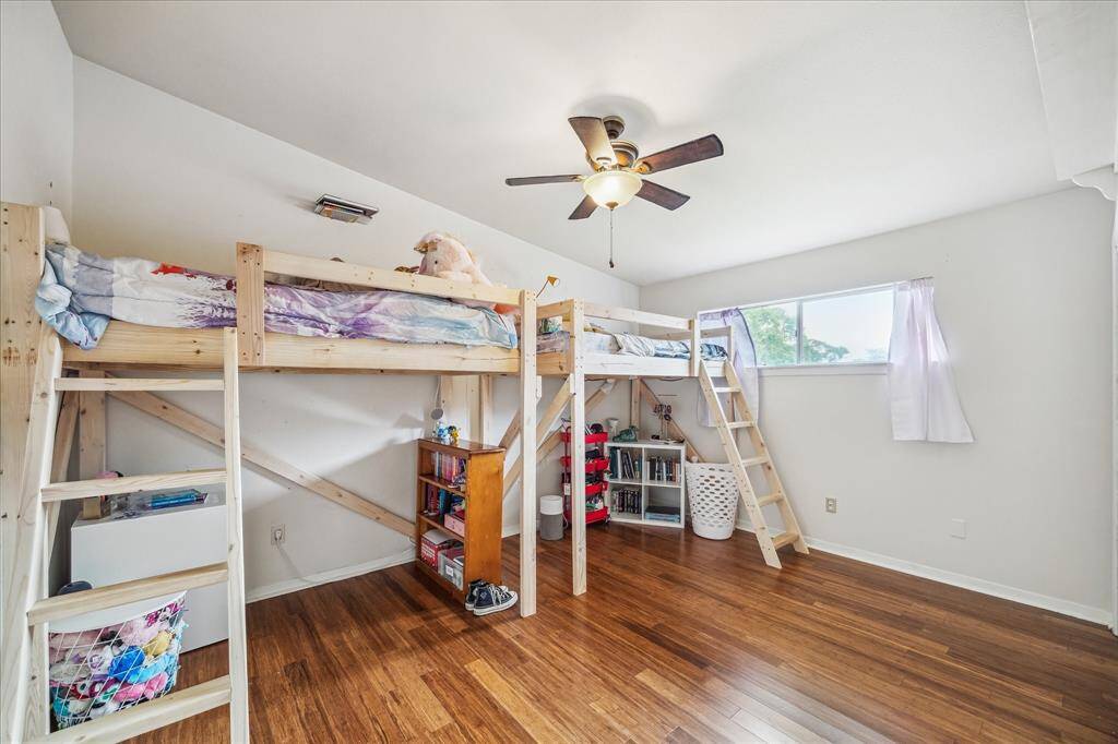 Secondary bedroom with wood flooring and vaulted ceiling.