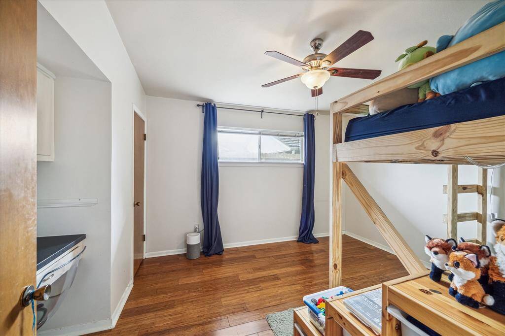 Another secondary bedroom that also has the ceiling fan and wood flooring.