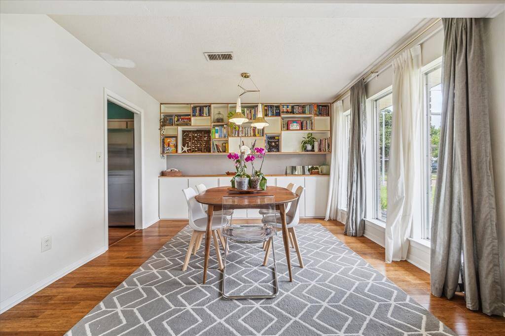 The far end of the space is currently utilized as a more formal dining and study.  Wonderful original zoomy vintage light fixture and wall of custom built ins.