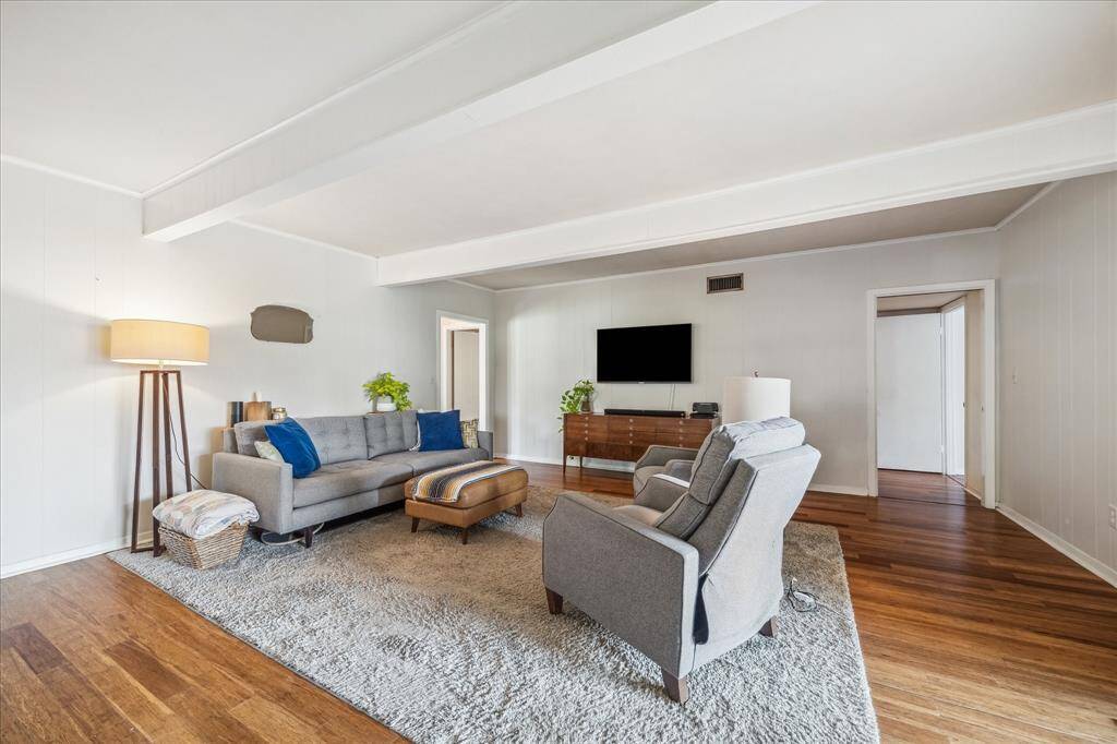 The flooring extends into the huge family room with a beamed ceiling.  Plenty of room for a large scale flat screen or your art.