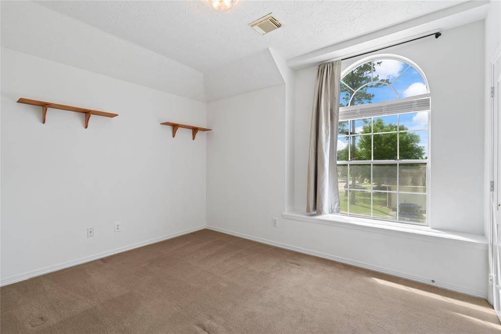 This generously sized secondary bedroom features fresh paint, a large window, and a spacious closet, offering a bright and comfortable space for family or guests.