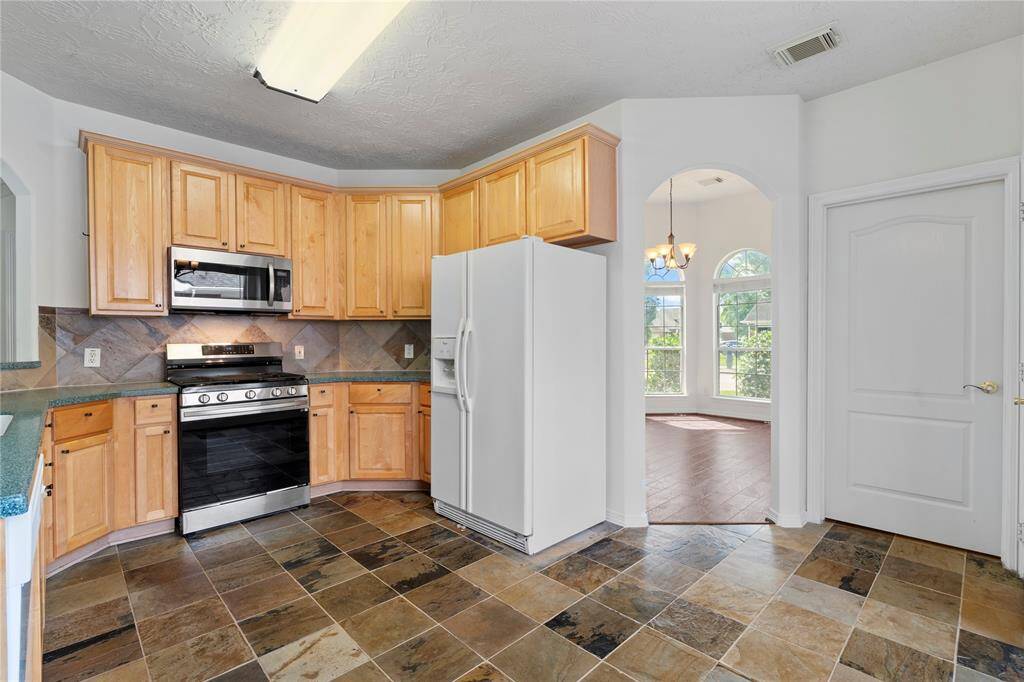 The kitchen offers a warm, inviting atmosphere with an open layout perfect for multitasking just steps away from the dining spaces.