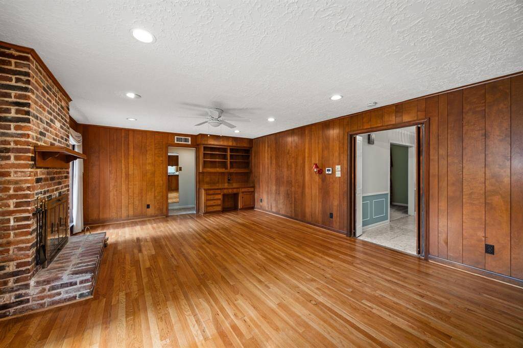Family room view to primary bedroom hall on left and foyer on right