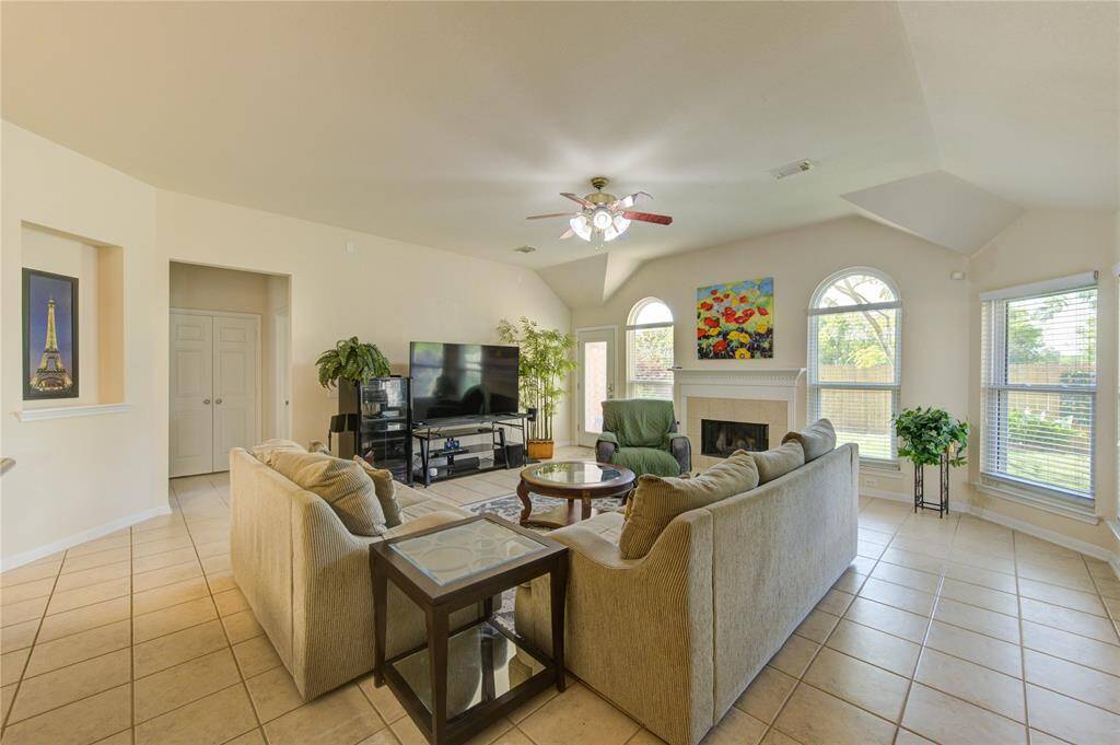 Gather in the expansive family room, where a charming fireplace is flanked by oversized windows that fill the space with warmth and sunlight.