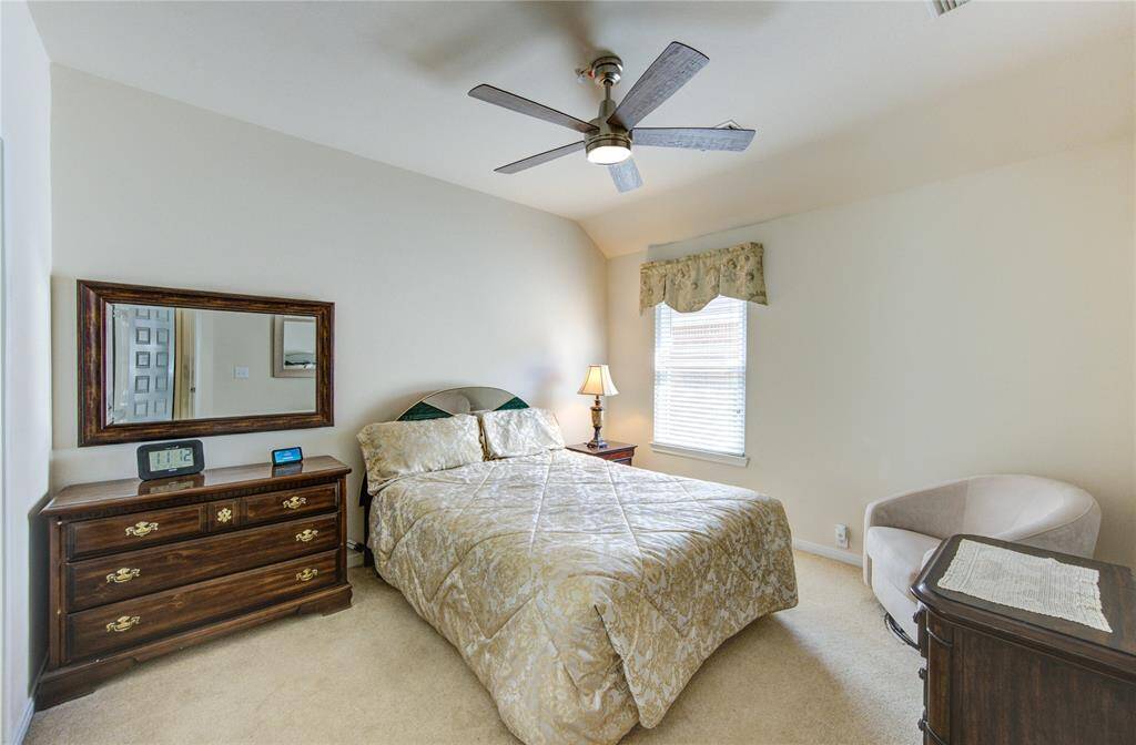 This secondary bedroom number 2 offers a charming angled ceiling, plush carpeting, and beautiful natural light that enhances its warm and welcoming feel.