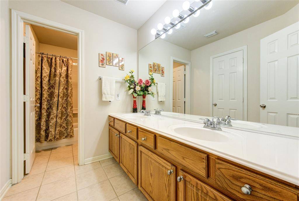 Full bath number two features dual sinks, abundant cabinet storage, and a convenient tub/shower combination—perfect for accommodating family or guests.
