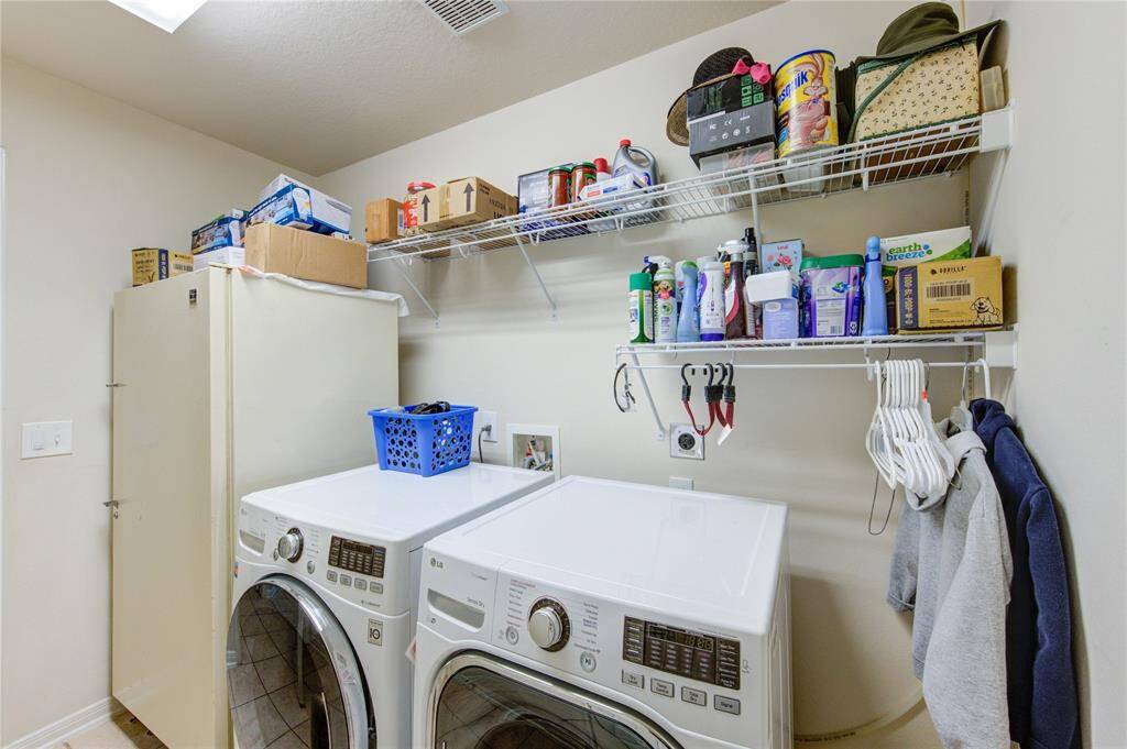 Enjoy the convenience of a generously sized laundry room, complete with shelving to keep essentials neatly organized and within reach.
