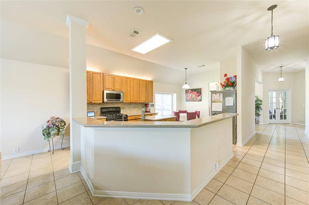 The kitchen is anchored by a wraparound silestone bar that not only adds style and functionality but also offers extra seating for guests to gather and enjoy.