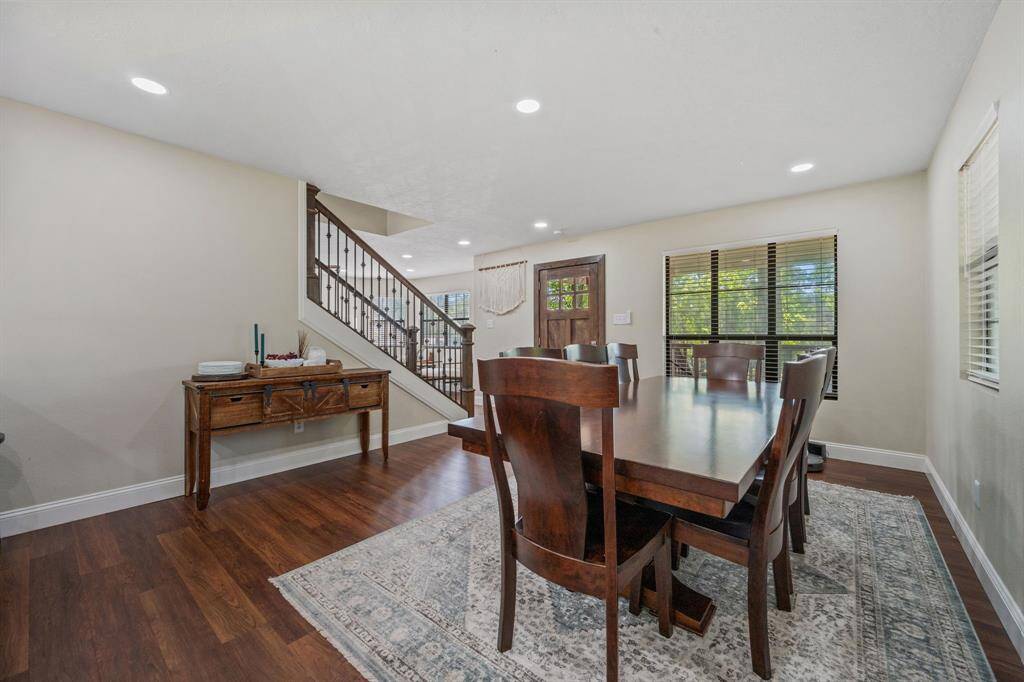 Another angle of this inviting dining area features ample room for entertaining and natural light from multiple windows. Again, the space is enhanced by recessed lighting showcasing the warm atmosphere of this home. You also have a great view of the staircase leading to the upper level.