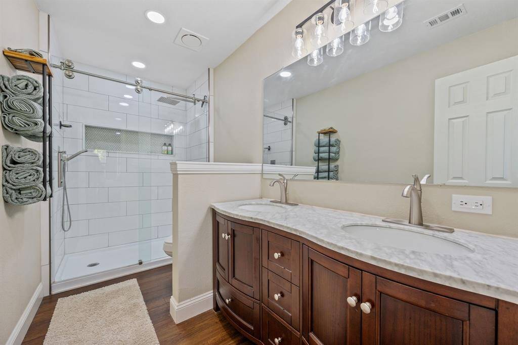 Inside the large bathroom attached to the primary bedroom. Again, this space features great amount of lighting and plenty of counter space.