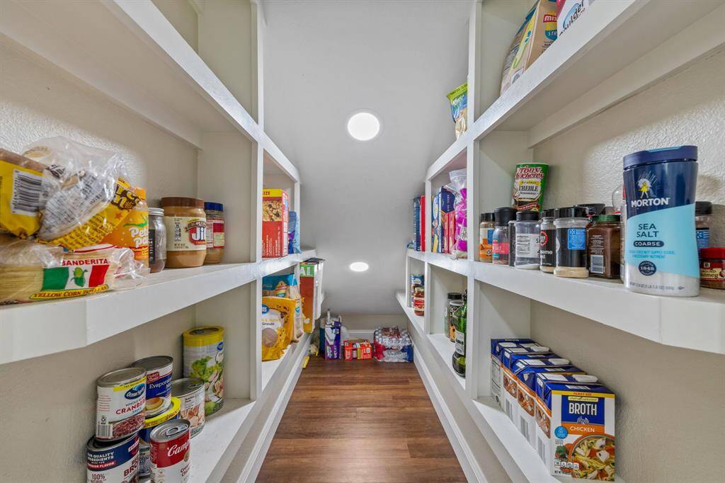 Making sure all space is utilized, under the staircase accessible to the kitchen, there is a spacious, well-organized pantry with multiple shelves. Its location makes it ideal for storage. With the recessed lights perfectly placed, there will be no digging in the dark for canned goods this pantry. it’s perfect for keeping kitchen essentials neatly arranged.