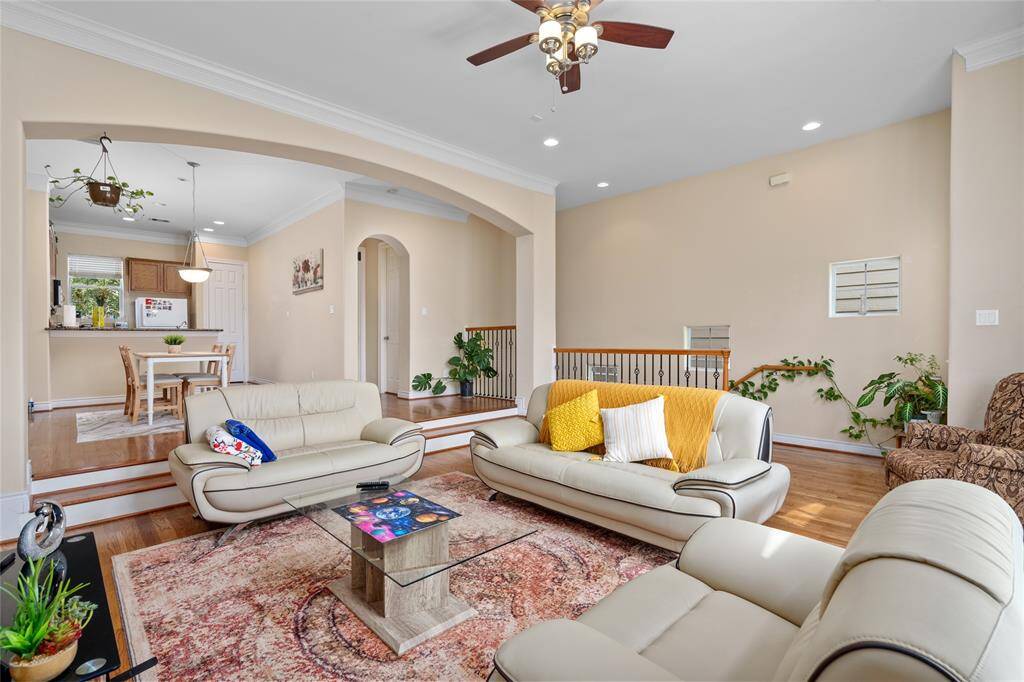 Spacious and light-filled, this living area features neutral tones and large windows that offer an inviting and open feel. The room flows seamlessly into adjacent spaces, creating a versatile setup for everyday living or entertaining.