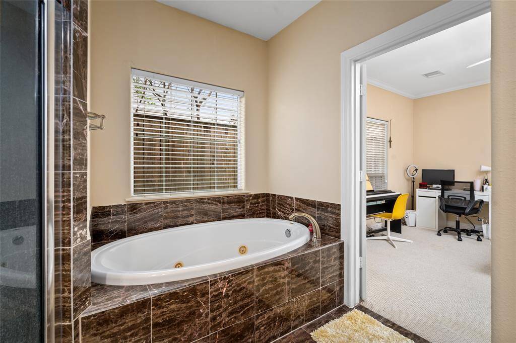 Bright en-suite bath with a clean layout, featuring a wide vanity, full tub/shower combo, and neutral finishes—ready for your personal touches.