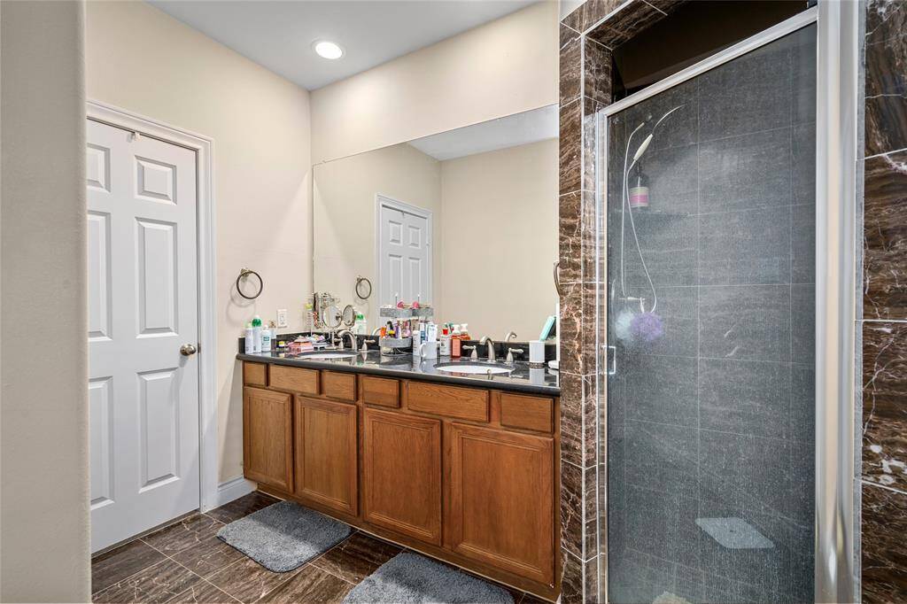 The primary bathroom has a separate shower with glass door and double sinks.