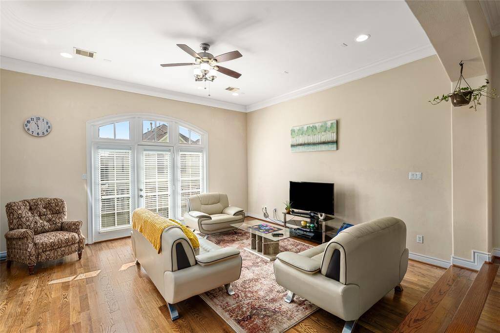 Bright and spacious living room featuring neutral tile flooring, soft wall tones, and generous natural light. The open layout offers a welcoming atmosphere with plenty of room for seating and effortless flow into the adjacent dining area.