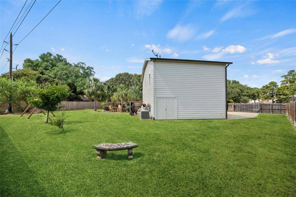 Completely level green, the backyard is shaped for playing and gardening.