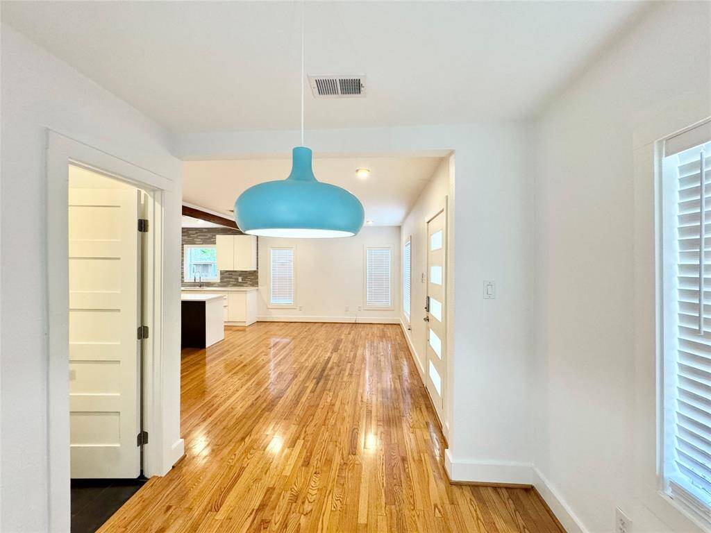 Contemporary pendant light marks the space. To the left is the door to the convenient half bath perfect for guests!
