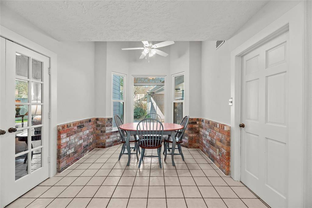 Bright breakfast area nook with a brick accent on the walls.  Overlooks the patio and pool area.