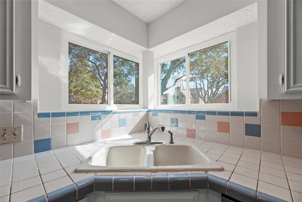 Kitchen features a corner sink area looking towards the front yard and driveway.