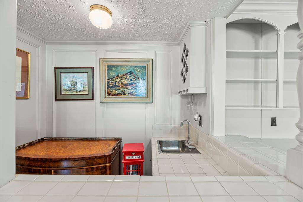 Wet Bar in the family room corner includes a small sink, featuring built-in shelves and wine storage.