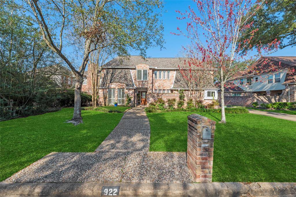 Home spanning 2,793 sq. ft., featuring a beautifully maintained front lawn with mature landscaping. Also, a brick walled courtyard to the Right of the entryway.