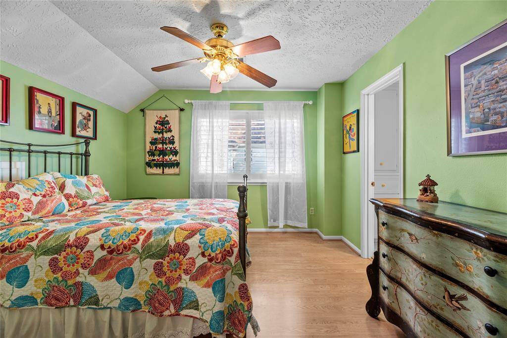 Second bedroom features laminated flooring and ceiling fan.