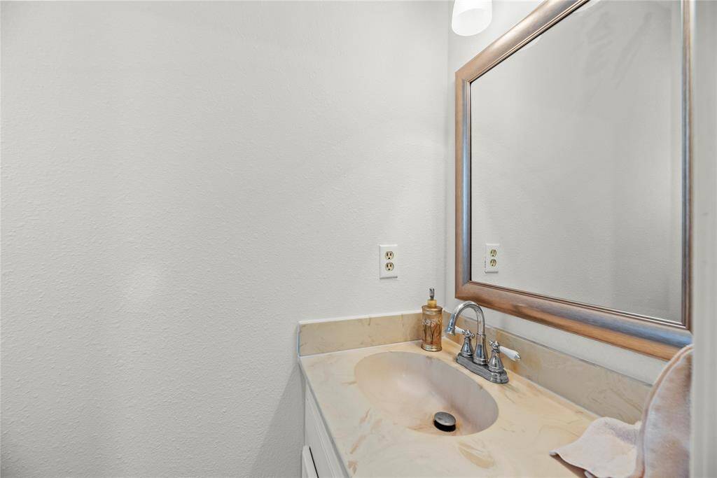 Half bath located on the first floor is conveniently near the utility room and can be used by inside or outdoor guests visiting the pool.