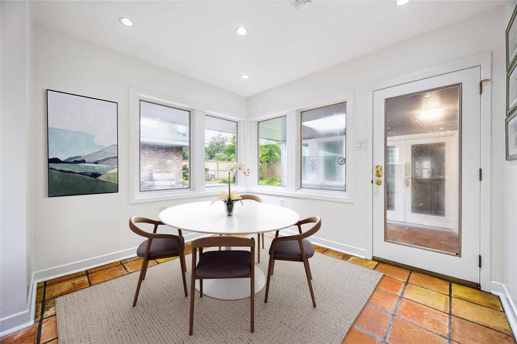 The kitchen offers seamless connectivity to the breakfast room, formal dining, and family room—perfect for both entertaining and daily living. Saltillo tile flooring and west-facing windows fill the space with character and light. Open, airy, and thoughtfully appointed.