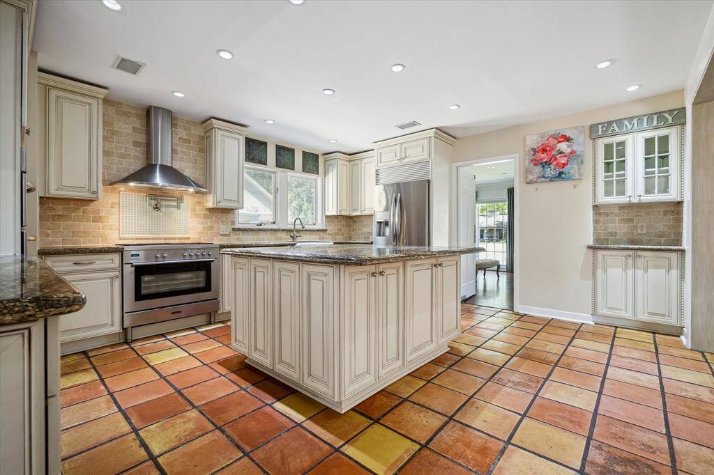 Granite countertops, deep drawer storage, and seamless flow to both formal and casual living areas define this elegant kitchen. The center island invites gathering and conversation. Designed with intention and finished with flair.