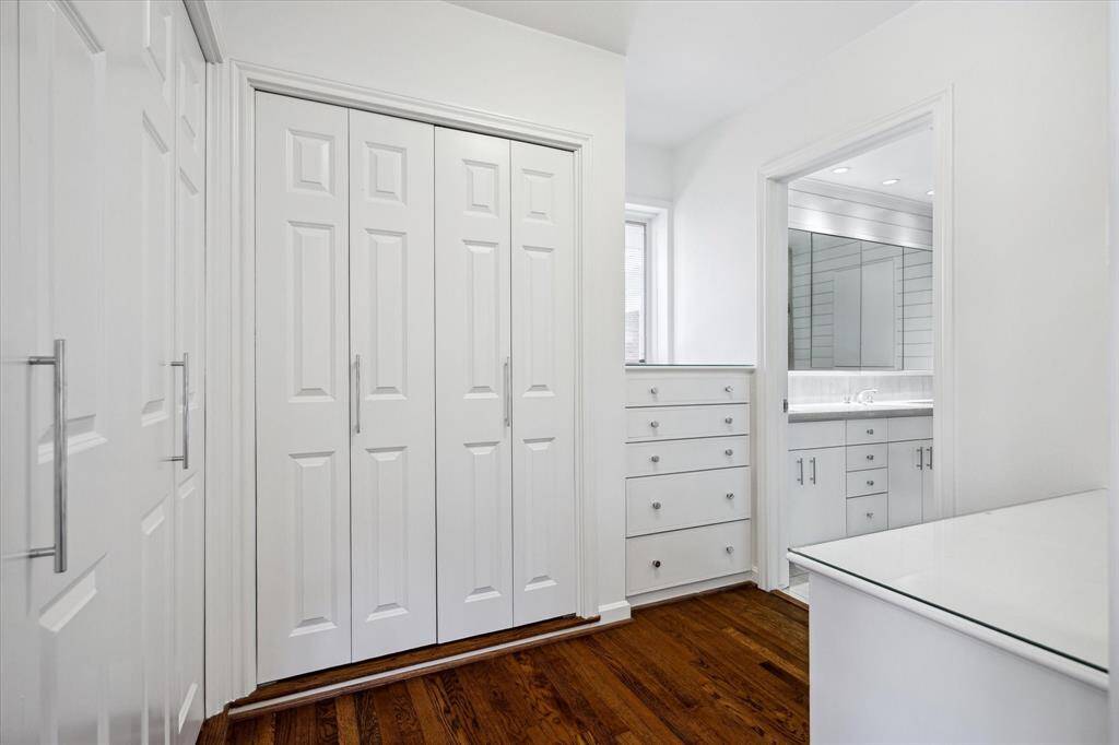 The dressing area offers custom built-in drawers, hanging space, and beautiful natural light from a well-placed window. Organization and elegance merge effortlessly here. A functional space designed to make everyday routines feel indulgent.