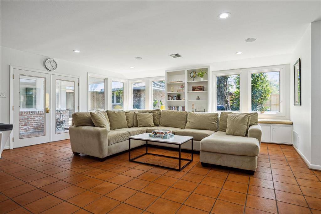A covered breezeway connects the main house to the guest quarters while framing a large paver patio. Ideal for grilling, dining al fresco, or cozying up around a fire pit. Outdoor living, elevated in every way.