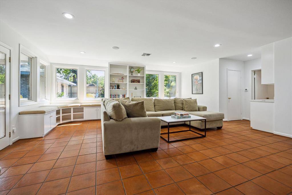 The guest house game room is framed in Saltillo tile and offers breezeway access to the main house and garage. Expansive windows frame backyard views, blending leisure and luxury. A perfect extension of the main home’s thoughtful design.